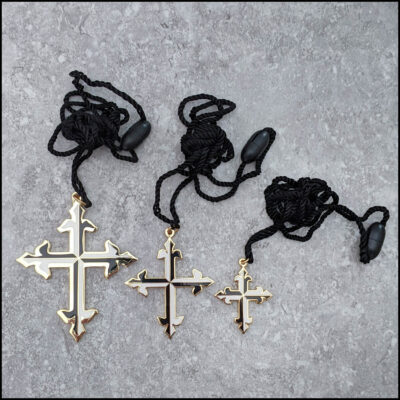 Black and white enameled gold-plated cross pendant on 24” black adjustable cord.